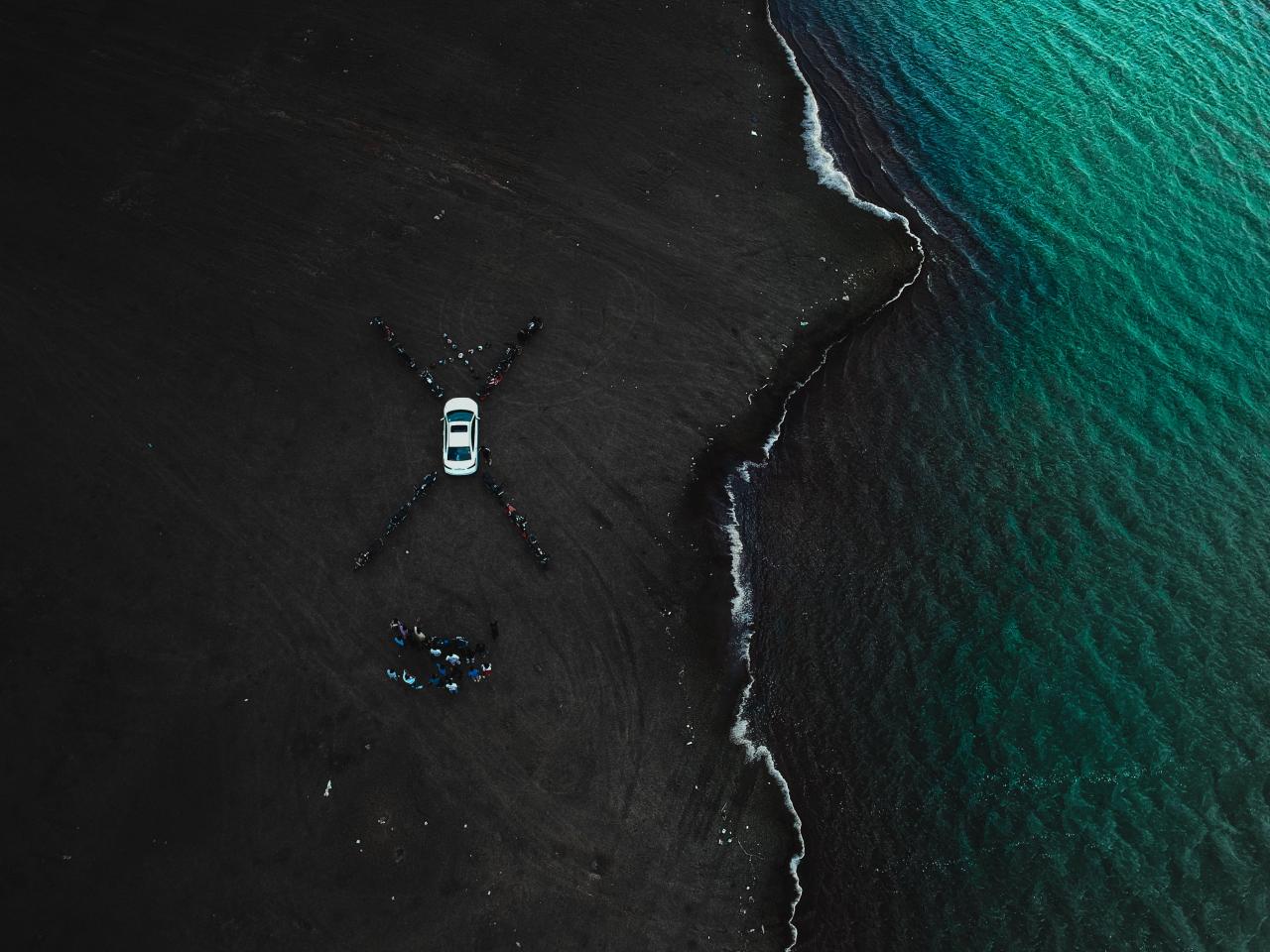 سيارة بيضاء متوقفة بالقرب من شاطئ البحر